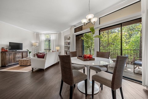 a living room with a table and chairs and a balcony